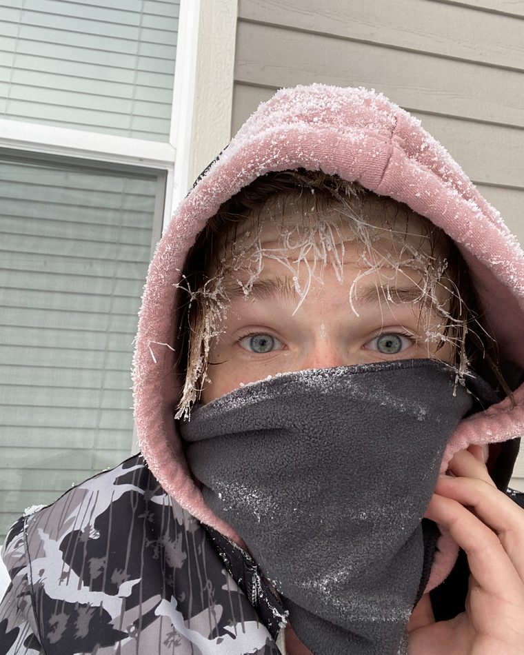 Eli bundled up against the cold in the early days, shoveling driveways before school