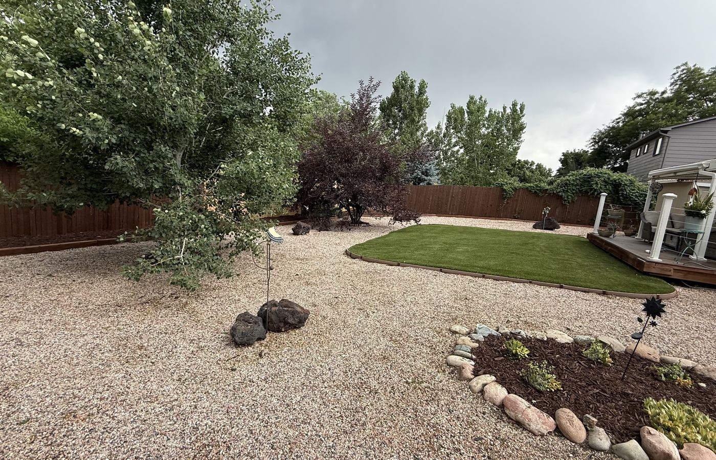 A finished rock and mulch yard with decorative rock and a green border